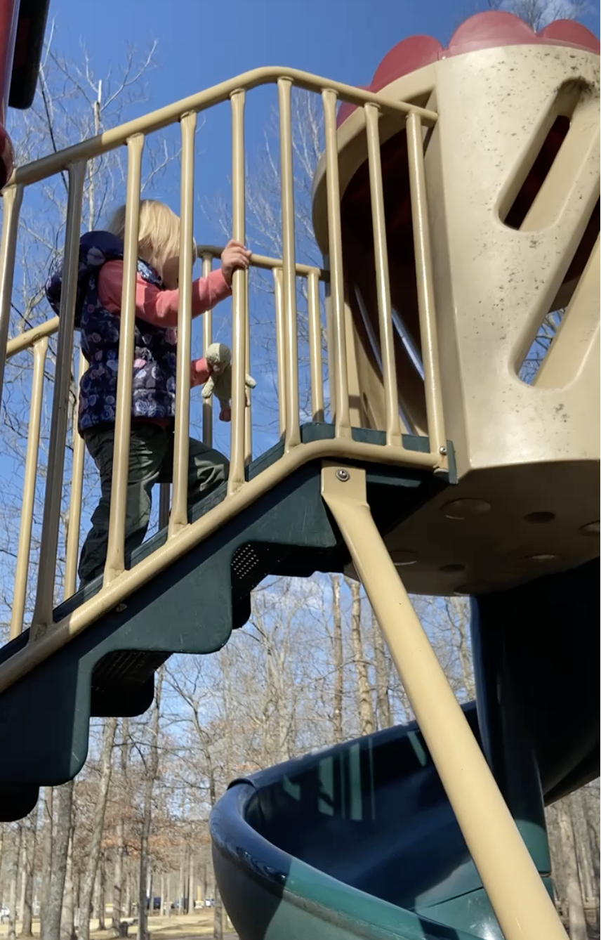 Kid climbing up the stairs to a slide